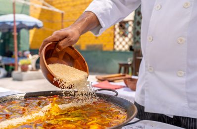 Chef,Adding,Rice,To,A,Delicious,Paella,From,A,Wooden